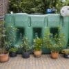 Bovengrondse Watertank 3000 liter met pomp in de tuin naast de bloemen