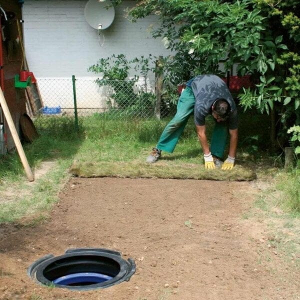 Toedekken met grasmatten van platte septische put Nordic