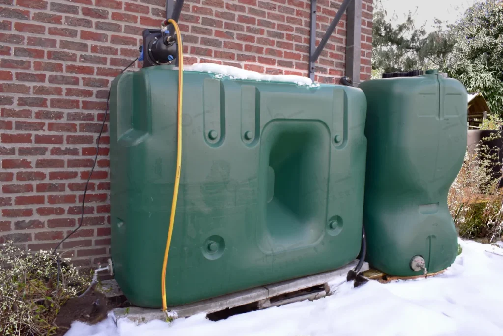 Bovengrondse watertank in de besneeuwde tuin.