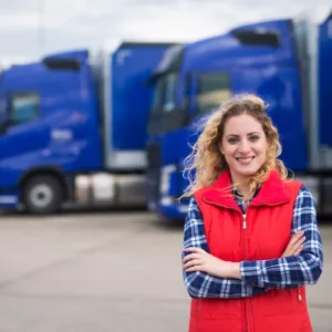 Vrouwelijke transportmanager voor een rij vrachtwagens, illustrerend hoe Ad Blue tanks efficiënt vlootbeheer en kostenbesparing mogelijk maken.