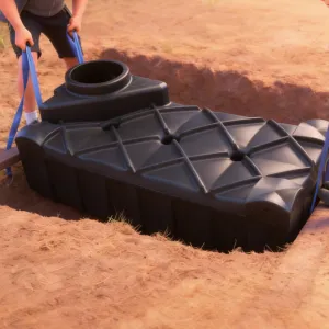 Septische put plaatsen Stap 4: De rechthoekige septische tank van 240 cm gecontroleerd laten zakken met blauwe hijsbanden die volledig onder de tank doorlopen.